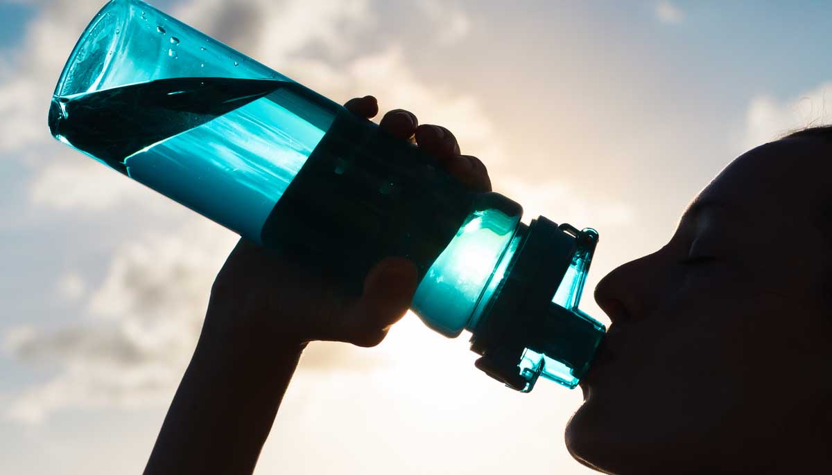 Woman drinking from large bottle of water