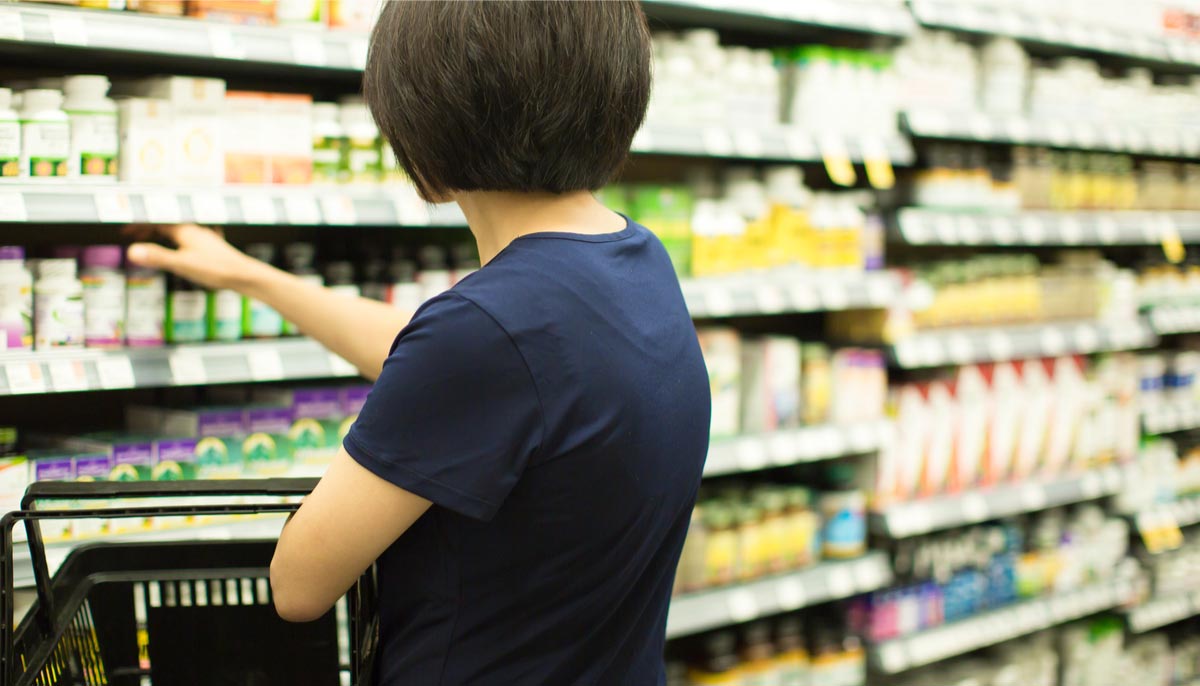 A woman browsing shelves stocked with supplements